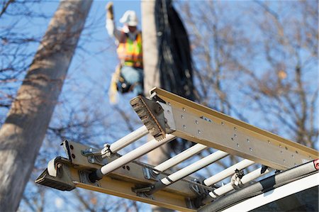 Ladder on a truck and lineman working on power pole Stock Photo - Premium Royalty-Free, Code: 6105-07521274