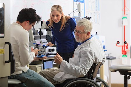 Professor with muscular dystrophy working with engineering students setting up adjustable stage at chemical analysis instrument in a laboratory Photographie de stock - Premium Libres de Droits, Code: 6105-07521367