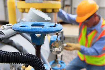 Engineer at electric power plant working with manual valves Stock Photo - Premium Royalty-Free, Code: 6105-07521475