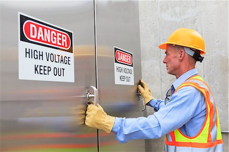 Engineer at electric power plant opening high voltage area doors Stock Photo - Premium Royalty-Free, Code: 6105-07521479