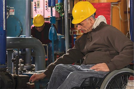 pipeline with man photos - Power plant engineer with spinal cord injury reviewing process equipment in power plant Stock Photo - Premium Royalty-Free, Code: 6105-07744443