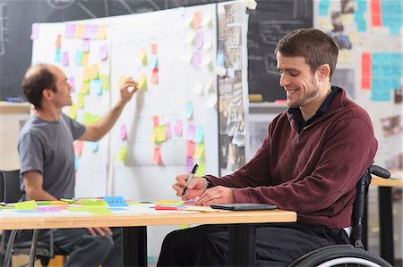 student (male) - Engineering students posting brainstorming ideas on project board, one man with spinal cord injury and other one with Aspergers Stock Photo - Premium Royalty-Free, Code: 6105-07744466