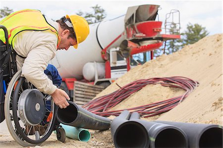 Construction supervisor with Spinal Cord Injury inspecting drainage pipes Stock Photo - Premium Royalty-Free, Code: 6105-07744514