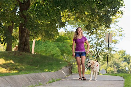 Woman with visual impairment walking with her service dog Stock Photo - Premium Royalty-Free, Code: 6105-08211237