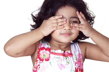 Portrait of a young girl covering her eyes with her hands Stock Photo - Premium Royalty-Free, Code: 6107-06117585