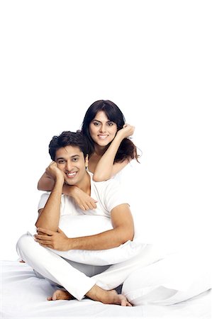 family white background full body - Portrait of a happy couple sitting on bed Stock Photo - Premium Royalty-Free, Code: 6107-06117913