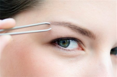 eyebrow - Woman plucking her eyebrow, close up (studio) Stock Photo - Premium Royalty-Free, Code: 6108-05855697