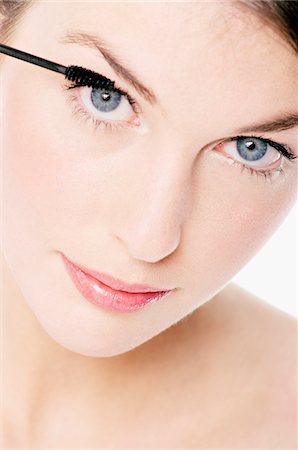 Young Woman face making-up with mascara, close-up (studio) Stock Photo - Premium Royalty-Free, Code: 6108-05855621