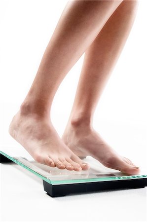 Young woman on scales, close up (studio) Stock Photo - Premium Royalty-Free, Code: 6108-05855896