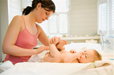 female changing a diaper - Mother and naked baby, milk cleanser Stock Photo - Premium Royalty-Free, Code: 6108-05856050