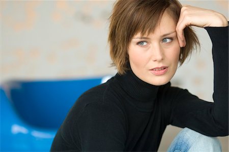 simsearch:6108-05859747,k - Young woman sitting on the floor, looking away Stock Photo - Premium Royalty-Free, Code: 6108-05856489
