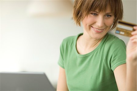 people holding cards in hand - Young smiling woman using laptop computer, holding credit card Stock Photo - Premium Royalty-Free, Code: 6108-05856504