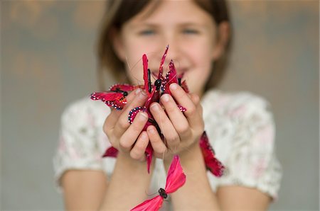 Little girl holding butterfly garland, close-up Stock Photo - Premium Royalty-Free, Code: 6108-05856658