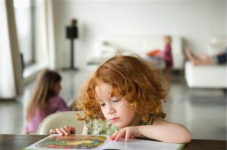 Little girl reading children's book Stock Photo - Premium Royalty-Free, Code: 6108-05856662