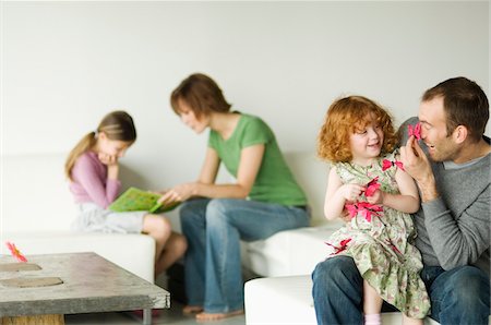 family games - Couple and 2 little girls sitting in the living-room Stock Photo - Premium Royalty-Free, Code: 6108-05856608