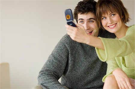 simsearch:6108-05858292,k - Smiling couple taking picture with camera phone Stock Photo - Premium Royalty-Free, Code: 6108-05856778