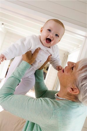 Senior woman lifting baby girl in the air Stock Photo - Premium Royalty-Free, Code: 6108-05856894