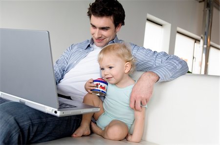 Man and little boy using laptop computer Stock Photo - Premium Royalty-Free, Code: 6108-05856819