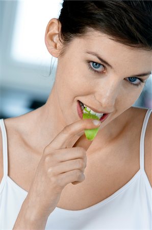 Portrait of a young woman eating apple slice Stock Photo - Premium Royalty-Free, Code: 6108-05856977