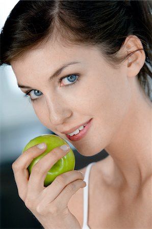 Portrait of a young woman eating an apple Stock Photo - Premium Royalty-Free, Code: 6108-05856986