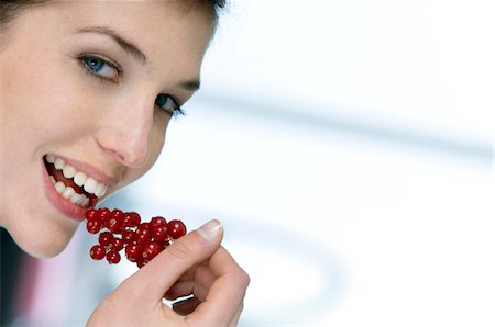 Portrait of a woman eating redcurrants Stock Photo - Premium Royalty-Free, Code: 6108-05856937