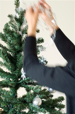 Woman hanging decoration on Christmas tree, close-up Stock Photo - Premium Royalty-Free, Code: 6108-05857117