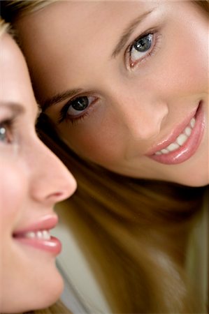 Portrait of a young woman looking at herself in a mirror Stock Photo - Premium Royalty-Free, Code: 6108-05857353
