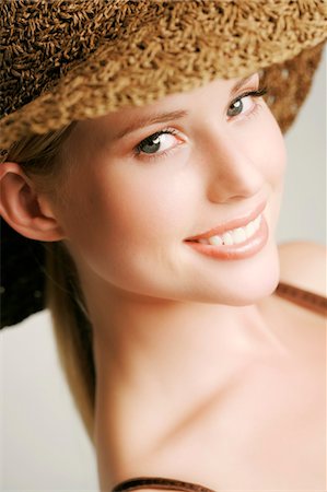 simsearch:6108-05857519,k - Portrait of a young woman looking at the camera, straw hat, indoors (studio) Stock Photo - Premium Royalty-Free, Code: 6108-05857323