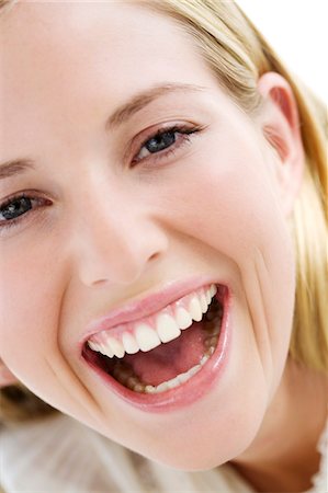 simsearch:6108-05857519,k - Portrait of a young woman laughing, indoors (studio) Stock Photo - Premium Royalty-Free, Code: 6108-05857338