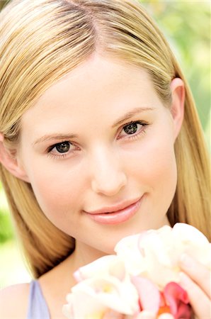 simsearch:6108-05857519,k - Portrait of a young  blond woman smiling, holding petals, outdoors Stock Photo - Premium Royalty-Free, Code: 6108-05857567