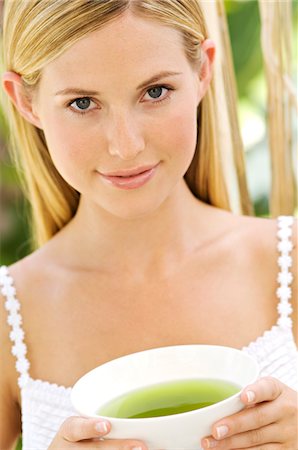 simsearch:6108-05857519,k - Portrait of a young woman looking at the camera, holding a green tea cup, outdoors Stock Photo - Premium Royalty-Free, Code: 6108-05857571