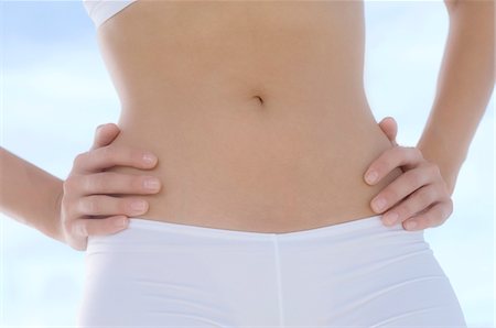 stomach in the abdomen - Woman with arms akimbo, close-up Stock Photo - Premium Royalty-Free, Code: 6108-05857504