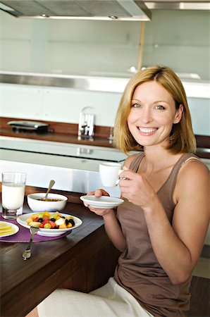 simsearch:6108-05864945,k - Smiling woman having breakfast Stock Photo - Premium Royalty-Free, Code: 6108-05857682
