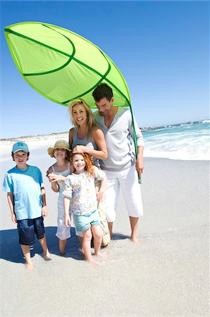 simsearch:6108-05858141,k - Parents and three children on the beach posing for the camera, outdoors Stock Photo - Premium Royalty-Free, Code: 6108-05858087