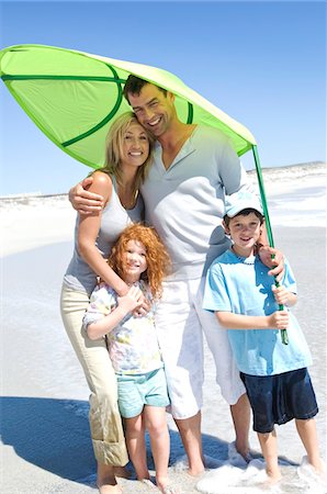 simsearch:6108-05858128,k - Parents and two children on the beach, posing for the camera, outdoors Stock Photo - Premium Royalty-Free, Code: 6108-05858084