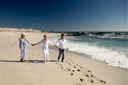 foot prints beach - Couple and senior woman holding hands on beach Stock Photo - Premium Royalty-Free, Code: 6108-05858169