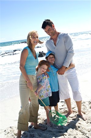 simsearch:6108-05858128,k - Parents and two children on the beach, posing for the camera, outdoors Stock Photo - Premium Royalty-Free, Code: 6108-05858114