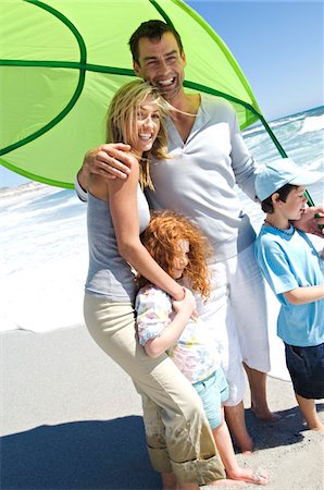 simsearch:6108-05858260,k - Couple and two children on the beach, outdoors Stock Photo - Premium Royalty-Free, Code: 6108-05858136