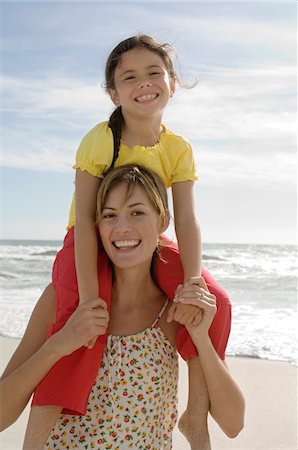 simsearch:6108-05858141,k - Portrait of a mother carrying her daughter in her shoulders, beach, outdoors Stock Photo - Premium Royalty-Free, Code: 6108-05858138