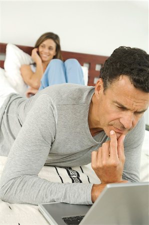 simsearch:6108-05857751,k - Couple in bedroom, man using laptop, indoors Stock Photo - Premium Royalty-Free, Code: 6108-05858294