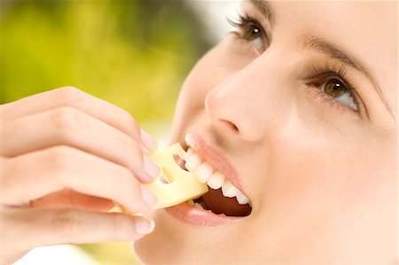 Portrait of a young woman eating a piece of gruyere cheese, outdoors Foto de stock - Sin royalties Premium, Código: 6108-05858367