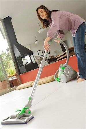simsearch:6108-05858292,k - Woman vacuuming, indoors Stock Photo - Premium Royalty-Free, Code: 6108-05858312