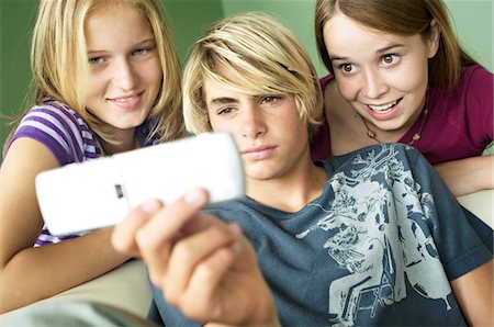 3 teenagers using camera phone Stock Photo - Premium Royalty-Free, Code: 6108-05858617
