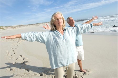 footprints of two people - Couple with arms out on the beach, eyes closed Stock Photo - Premium Royalty-Free, Code: 6108-05858769