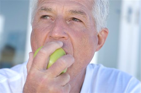 dreaming about eating - Portrait of man eating an apple Stock Photo - Premium Royalty-Free, Code: 6108-05858770