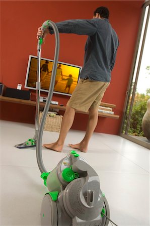 simsearch:6108-05858292,k - Man vacuuming, indoors Stock Photo - Premium Royalty-Free, Code: 6108-05858890