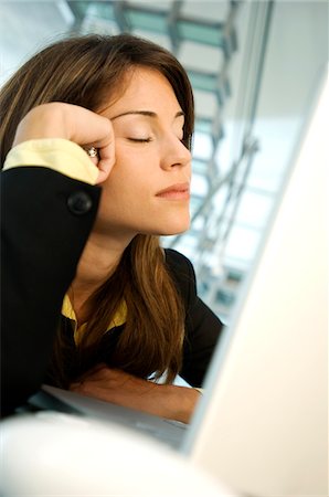 sleepy - Businesswoman sitting with eyes closed, side view Stock Photo - Premium Royalty-Free, Code: 6108-05859235