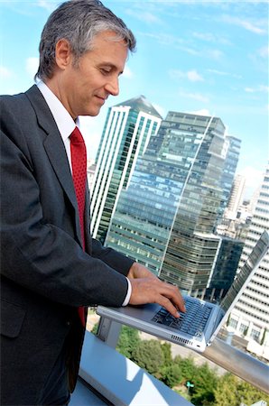 Mature businessman using laptop in balcony Stock Photo - Premium Royalty-Free, Code: 6108-05859354