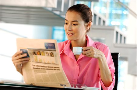 simsearch:6108-05856772,k - Businesswoman holding cup and reading newspaper in office Stock Photo - Premium Royalty-Free, Code: 6108-05859336