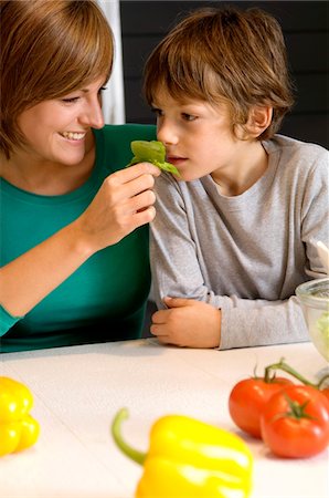simsearch:6108-05860153,k - Young woman feeding basil to her son Stock Photo - Premium Royalty-Free, Code: 6108-05859855